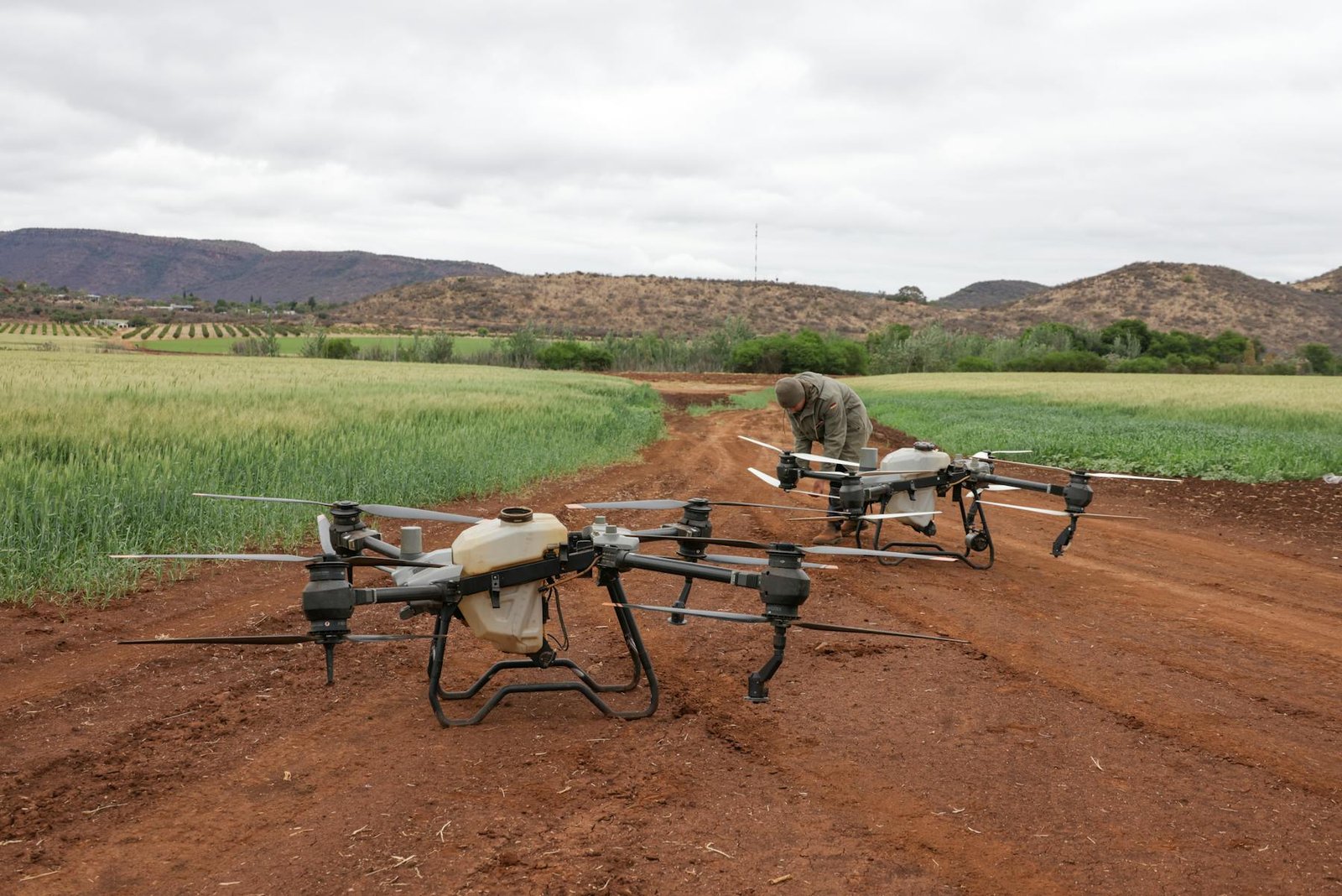 Agricultural drones flying over farmland for crop monitoring and precision agriculture.